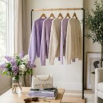 Minimalist wardrobe rack with lilac knits, white handbag and lilacs